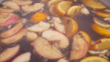 Yapma Satılık ülke adil de şarap mulled. Glintwine ile baharat, narenciye ve karanfil büyük metal stok pot, karışık çorba kepçe ile.