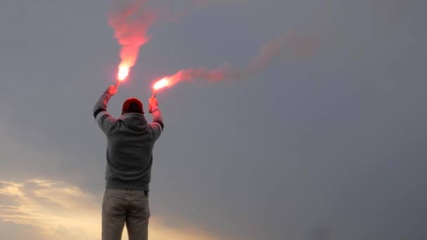 Man holds two signal fire. SOS signal with hand flare. — Stock Video