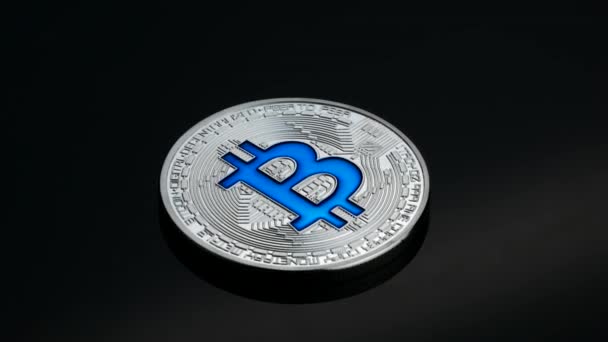 Rotierende Bitcoin-Kryptowährung Silbermünze blaues Logo schwarzer Hintergrund Geschäftskonzept — Stockvideo