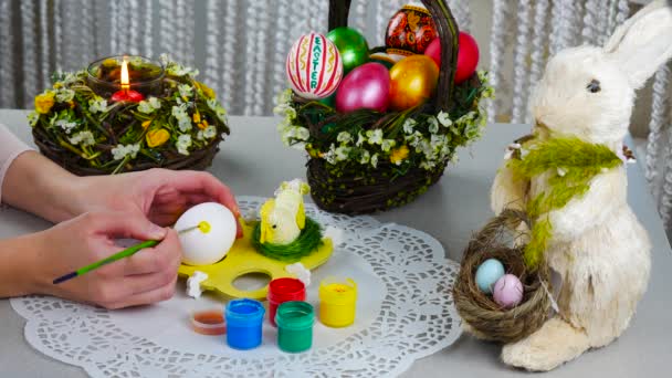 Frohe Ostern. junge Frauenhände bemalen ein Ei — Stockvideo