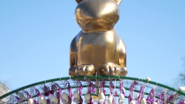 Oro Feliz conejo de Pascua en el fondo azul del cielo — Vídeos de Stock