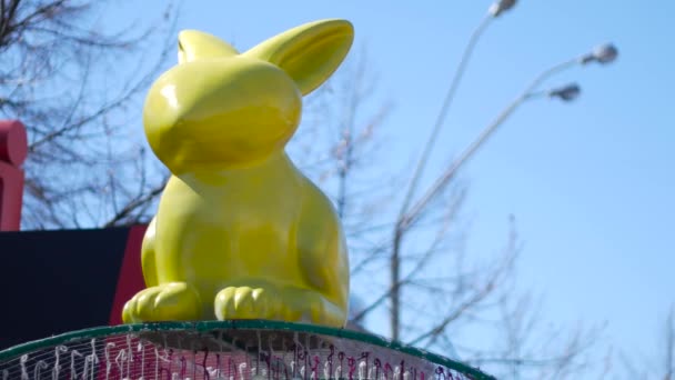 Riesige gelbe glückliche Osterhasen auf der Straße Hintergrund — Stockvideo