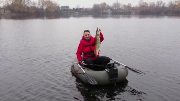 Pescador feliz con lucio del norte en un barco — Vídeos de Stock