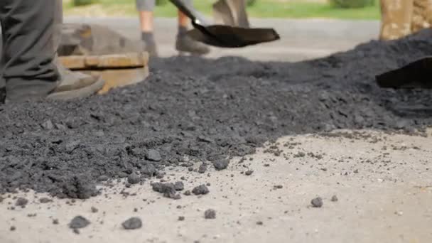 Los hombres con palas toman asfalto caliente para una nueva carretera — Vídeos de Stock