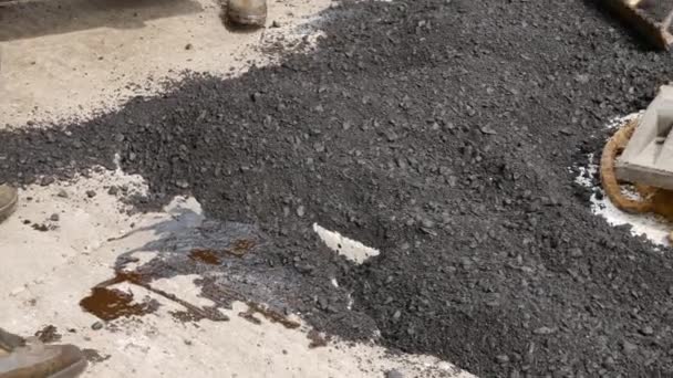Reparación de carreteras. Trabajador trae asfalto caliente con pala — Vídeo de stock