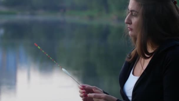 Портрет красивой девушки, готовящей рыболовные снасти — стоковое видео