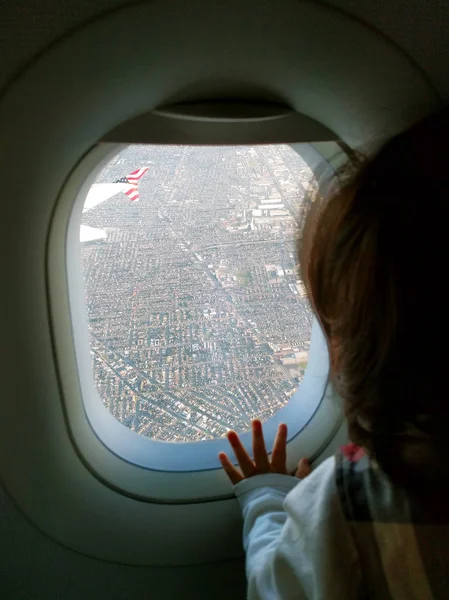 Bebê no avião olhando pela janela Imagem De Stock