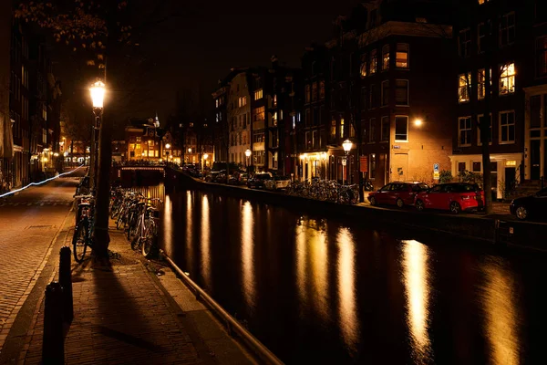 Amsterdam, Países Bajos - Nov 2017: Puente iluminado del canal por la noche en el canal entre Herengracht y Brouwersgracht . — Foto de Stock