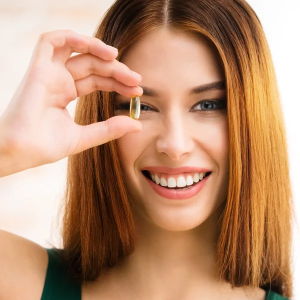 Mujer sonriente con Omega 3 cápsula de aceite de pescado — Foto de Stock