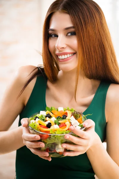 Bella giovane donna mangiare insalata, al coperto — Foto Stock