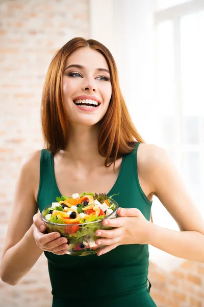 Красива молода жінка їсть салат, в приміщенні — стокове фото