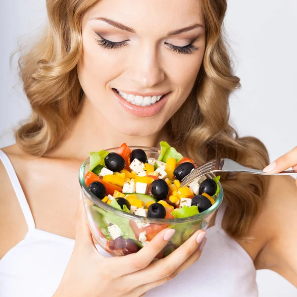 Vrouw met vegetarische salade, over grijs — Stockfoto