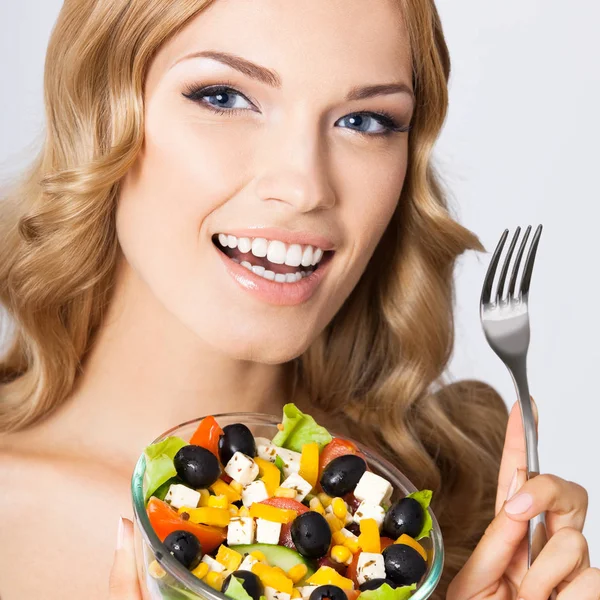 Vrouw met vegetarische salade, over grijs — Stockfoto