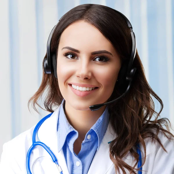 Smiling young doctor in headset, at office — Stock Photo, Image