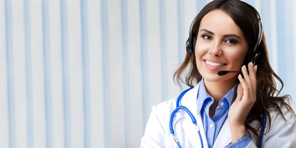 Uśmiechający się młody lekarz w słuchawki, w urzędzie — Zdjęcie stockowe