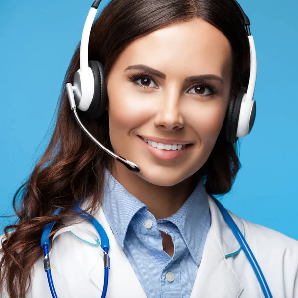 Feliz sorrindo jovem médico em fone de ouvido, em azul — Fotografia de Stock