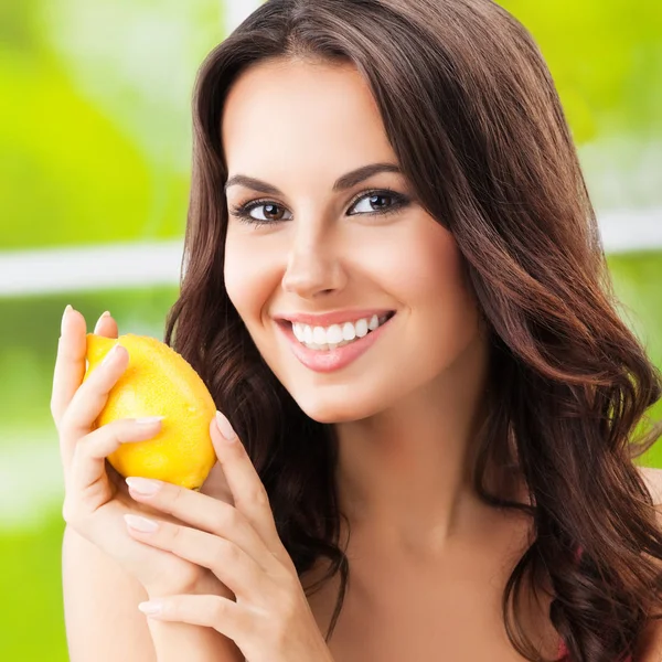 Щаслива усміхнена жінка з лимоном, на відкритому повітрі — стокове фото