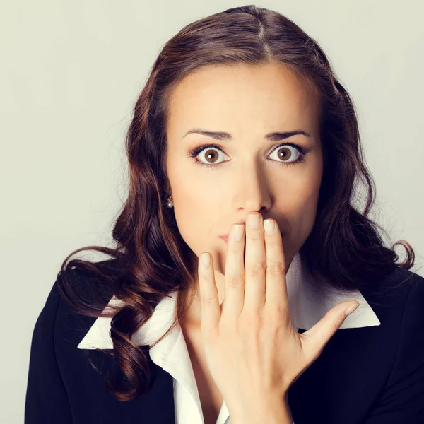 Business woman covering with hands her mouth Stock Picture