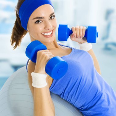 spor salonunda fitness egzersiz yaparak mutlu genç bir kadın