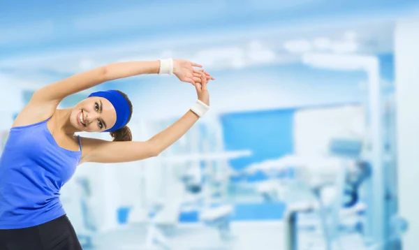 Молода щаслива жінка робить фізичні вправи, в спортзалі — стокове фото