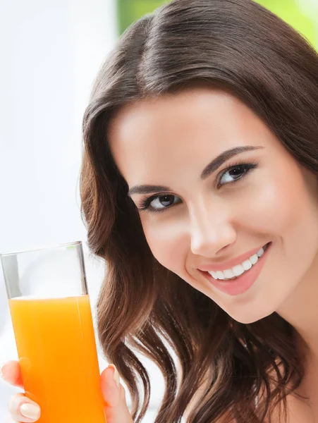 Feliz sorrindo jovem mulher bebendo suco de laranja — Fotografia de Stock