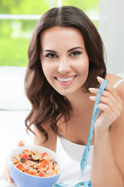 Kvinna äta tunt, med mått tejp, inomhus — Stockfoto