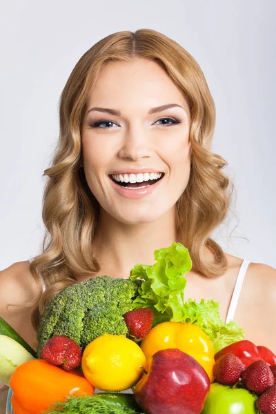 Jeune femme avec de la nourriture végétarienne, sur gris — Photo