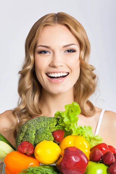 Mujer joven con comida vegetariana, sobre gris —  Fotos de Stock