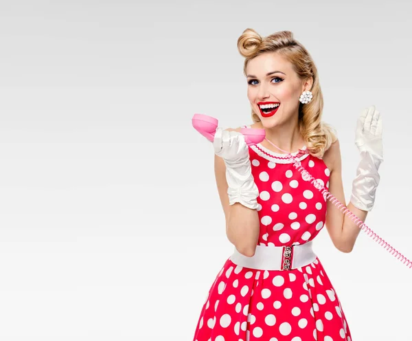 Smiling woman with phone, dressed in pin-up style dress — Stock Photo, Image