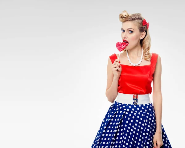 Giovane donna che mangia caramelle colorate, vestita in stile pin-up — Foto Stock