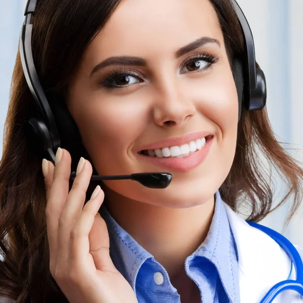 Smiling young doctor in headset, at office — Stock Photo, Image