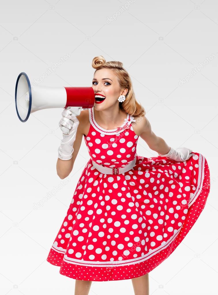 happy woman holding megaphone, dressed in pin-up style red dress