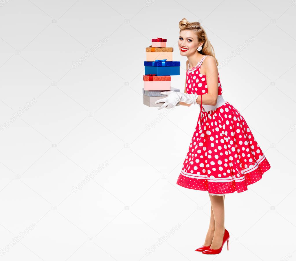Full body of woman in pin-up style red dress with gift boxes