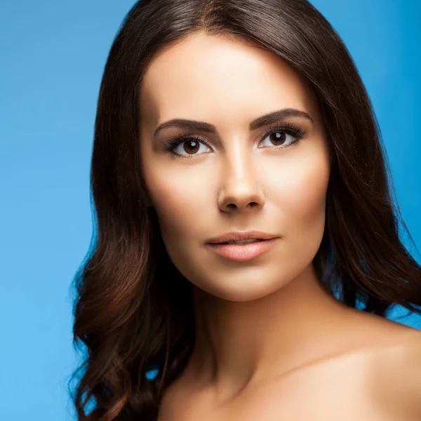 Portrait of beautiful young woman with naked shoulders, on blue — Stock Photo, Image