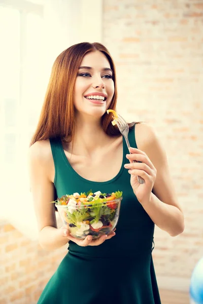 年轻漂亮的女人吃沙拉，室内 — 图库照片