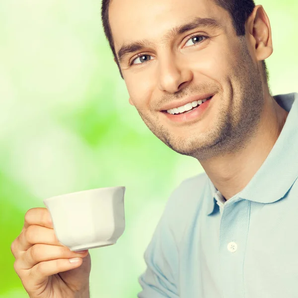 Heureux homme souriant boire du café, à l'extérieur — Photo