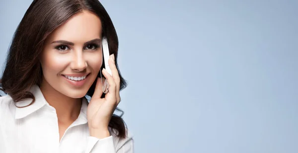 Businesswomen with cell phone, against grey — Stock Photo, Image