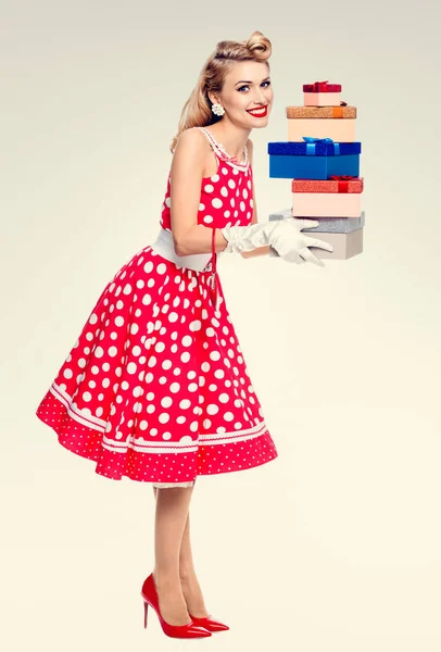 ギフト用の箱とピンナップ スタイルの赤いドレスを着た女性の全身 — ストック写真