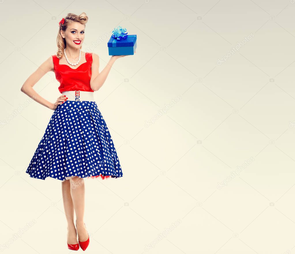 Full body of woman in pin-up style dress with gift box