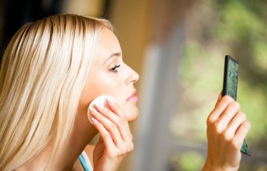 gülümseyen kadın evde krem uygulamak