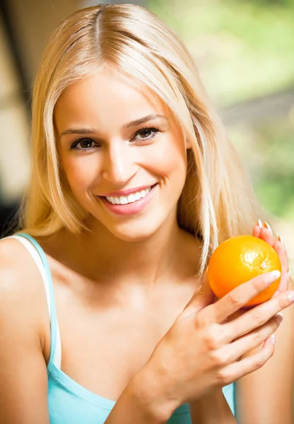 Woman with orange at home — Stock Photo, Image
