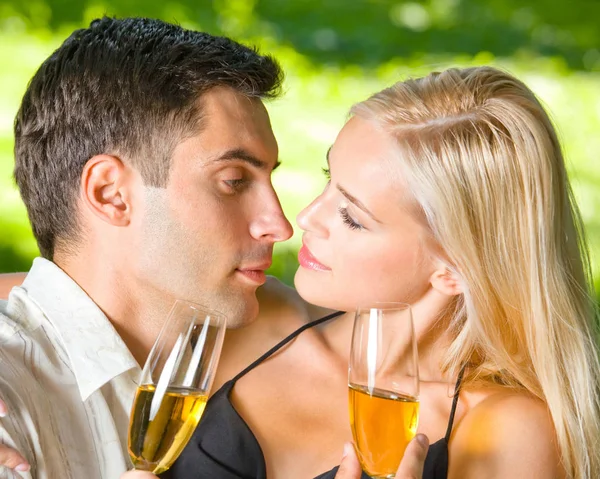 Счастливая пара празднует с шампанским, на открытом воздухе — стоковое фото