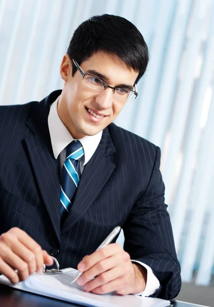 कार्यालय में काम करने वाले मुस्कुराते हुए व्यापारी लिखना — स्टॉक फ़ोटो, इमेज