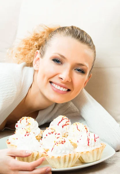 Жінка з тарілкою тортів вдома — стокове фото