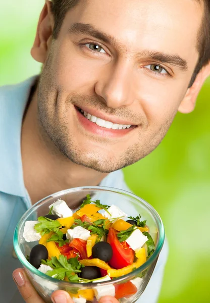 Glücklich lächelnder Mann mit einem Teller Salat, im Freien — Stockfoto