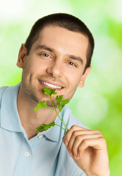 Felice uomo sorridente con potherbs, all'aperto — Foto Stock