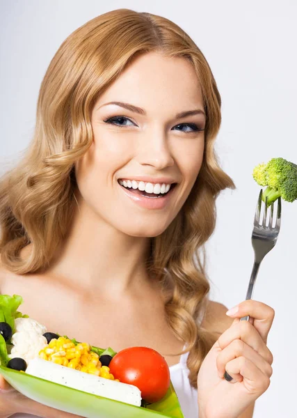 Mulher com salada vegetariana, sobre cinza — Fotografia de Stock