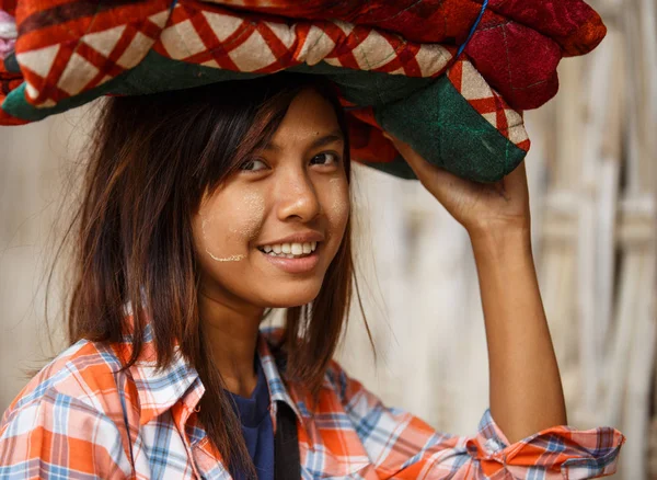 Chica llevando pila de ropa en la cabeza —  Fotos de Stock