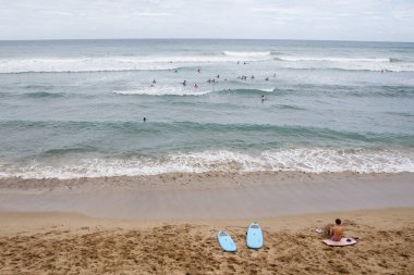 Deniz dalgaları yakalamaya çalışıyor Surfers