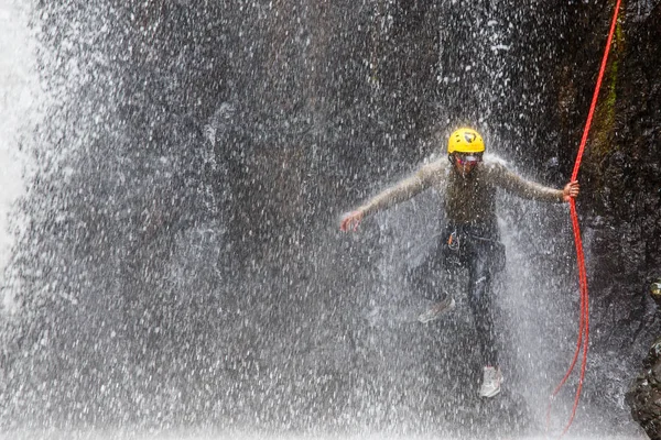Homem fazendo montanhismo na cachoeira — Fotografia de Stock